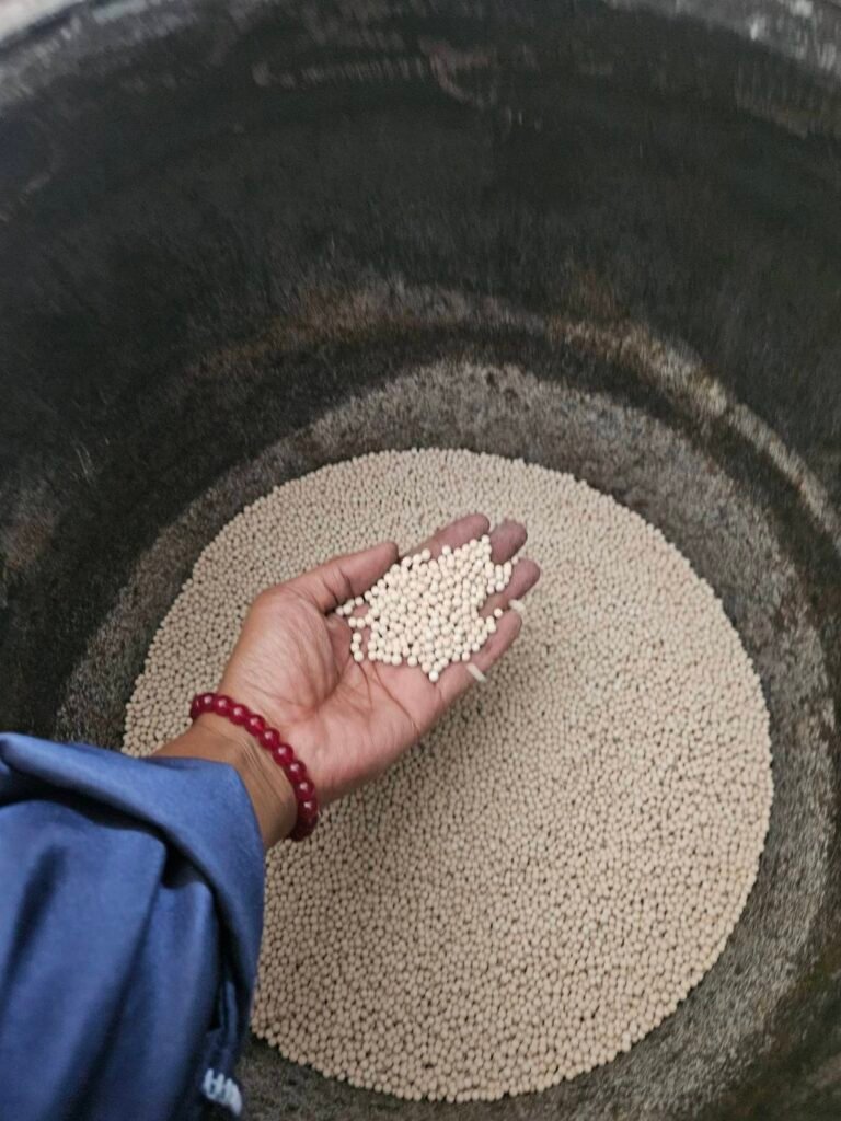 Media Replacement and Servicing for PSA Nitrogen Systems 3 White molecular sieve beads being poured into an open adsorption tower